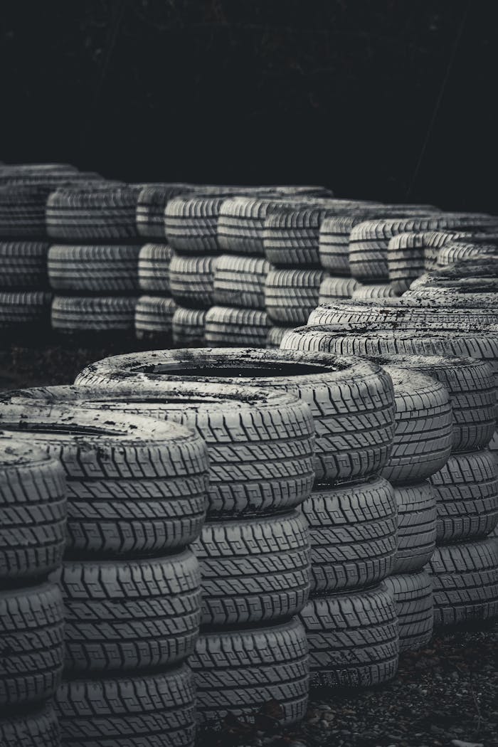 service-06 Vertical shot of stacked racing tires on a dark background for protection.