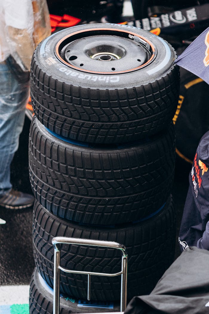 service-02 Close-up of stacked Formula 1 racing tires at a pit stop during a rainy day.
