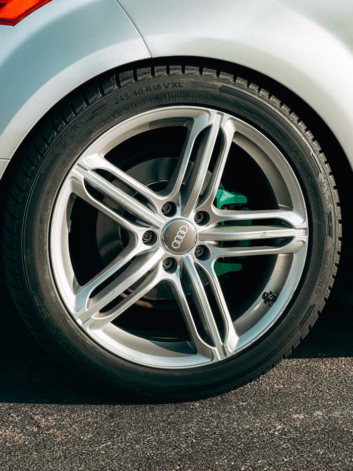 Detailed image of an Audi car wheel on asphalt with visible tire details.